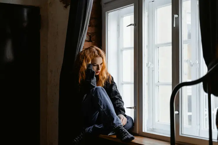 A woman sitting on a window sill
