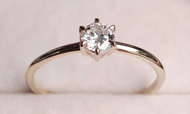 A colorless round cut memorial diamond, set in a ring.